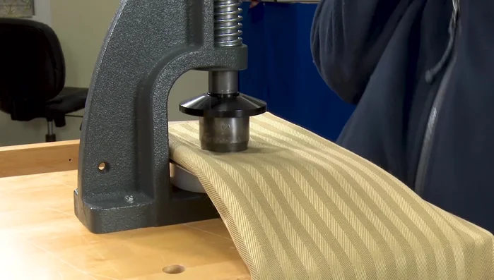 Use the hole cutter to create a hole in the center of the fabric circle.