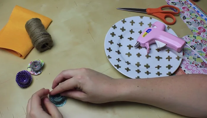 Once rolled, loosen the flower slightly to create a more natural look. Glue the tab to the center, ensuring all layers are secured with glue.