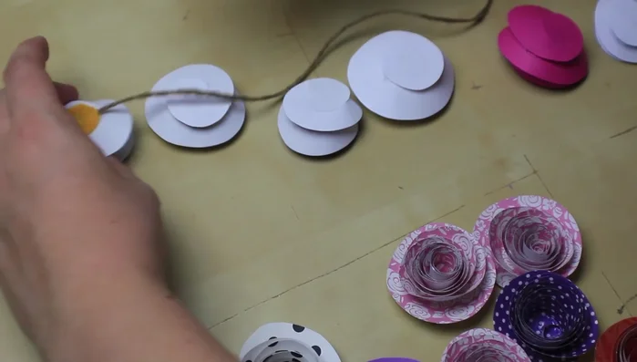 Continue gluing flowers upside down to the twine, adding felt circles to the back of each.