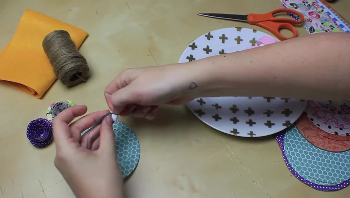 Once rolled, loosen the flower slightly to create a more natural look. Glue the tab to the center, ensuring all layers are secured with glue.