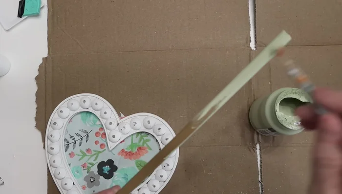 Attach a painted wooden dowel to the back of the heart.