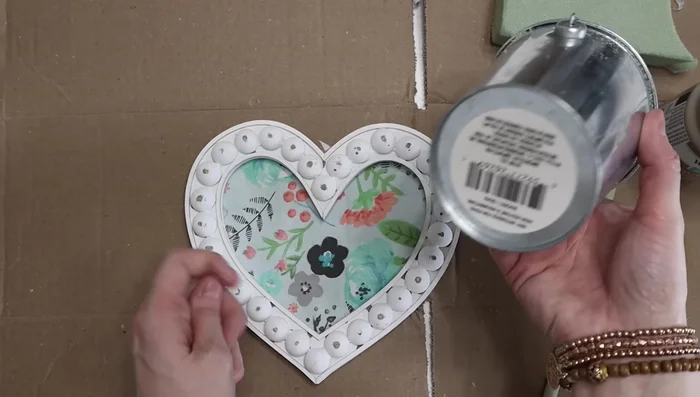 Insert the dowel into floral foam inside a galvanized bucket and add moss to hide the foam.