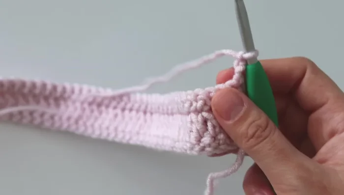 Repeat steps 2 & 3 until you reach the desired length, creating the cable pattern. The cable pattern involves making 3 double crochets, then a front post double crochet, followed by skipping a stitch and making 2 treble crochets, and repeating this sequence across the row.