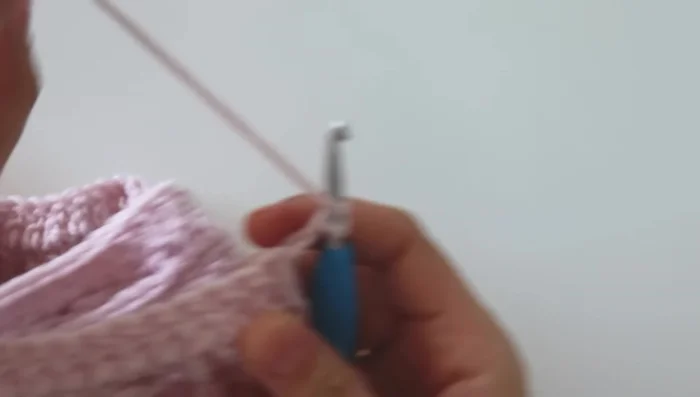 For the border, switch to a 5mm crochet hook. Chain 2, and work half double crochets around the entire blanket. At the corners, work two half double crochets, chain 2, then two more half double crochets.