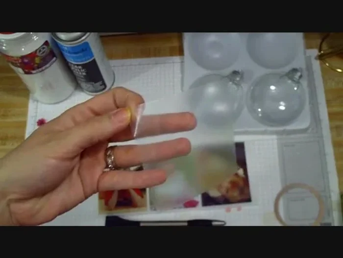 Position the photo on the ornament and peel off the clear film backing. Smooth out any wrinkles or bubbles, ensuring complete adhesion. Use a tool or fingers to gently press the image onto the ornament.