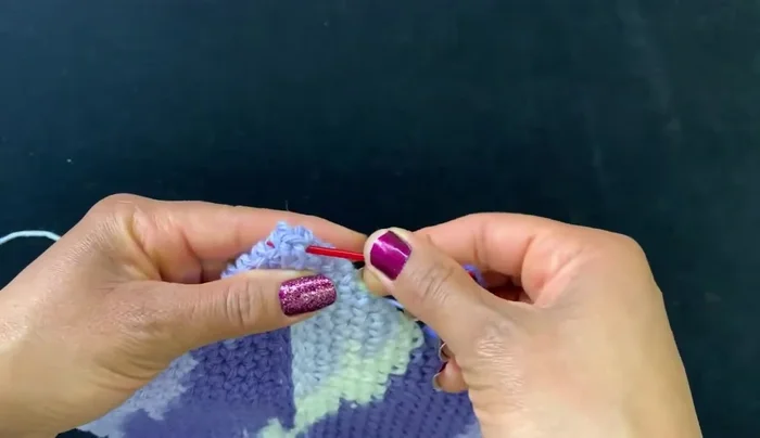 Flip the item over and secure the ring by weaving the yarn tail through several loops.