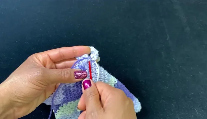 Flip the item over and secure the ring by weaving the yarn tail through several loops.