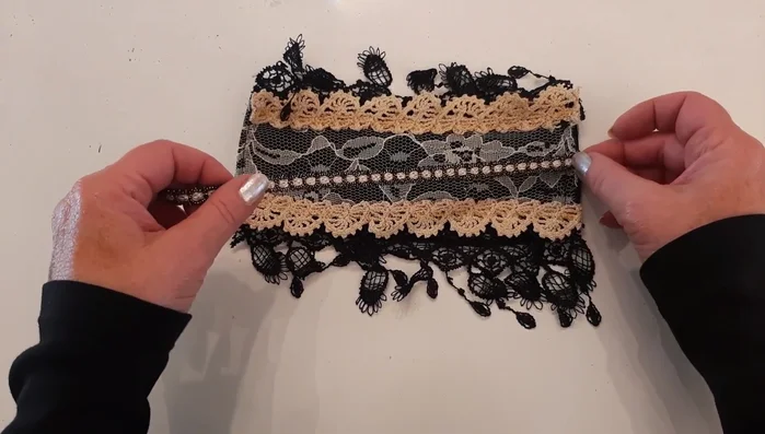 Sew a black and cream/gold fringed trim down the center of the cuff using a large zigzag stitch.