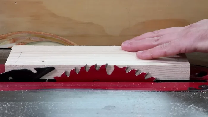 Lower the table saw blade to half the thickness of the board.