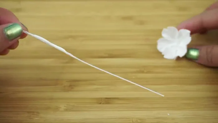 Assemble the flower: Apply glue below the stamens, insert the stem into the flower center, and squeeze the base closed. Remove excess clay.