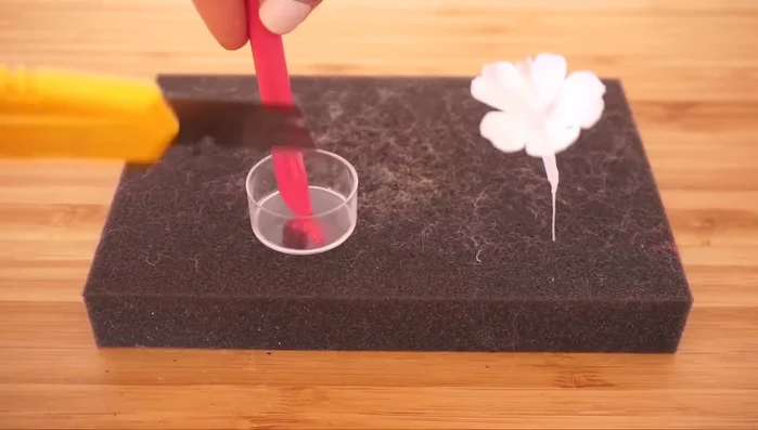 Add color: Use soft pastels to add color to the petals, and acrylic paints to create streaky orange pollen on the stamens. Use brown and green pastel dust on the stem.