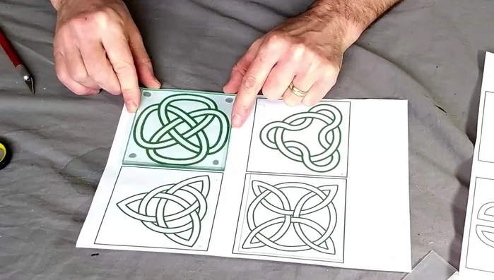 Secure the design: Blue tack your printed Celtic design (printed in green for visibility) to the coaster, ensuring it's square and the blue tack is out of the way of the design.