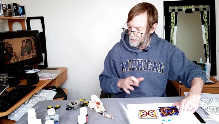 Create a mottled background: Mix white and a lighter green Pebeo paint for a mottled background. Apply this gently, avoiding bubbles, to the areas surrounding the red and yellow shapes.