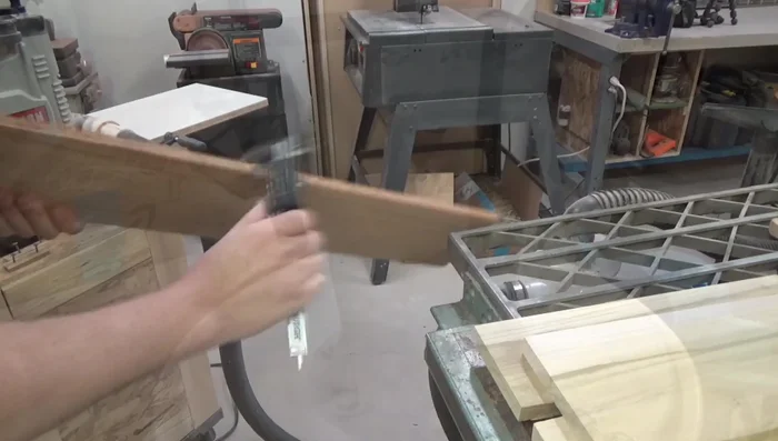 Cutting boards to desired width on table saw using a stop block.