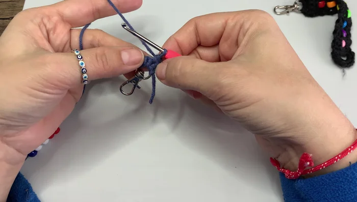 Crochet around the bead, working under the V-shape of the stitches.