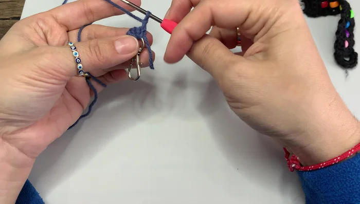 Crochet around the bead, working under the V-shape of the stitches.