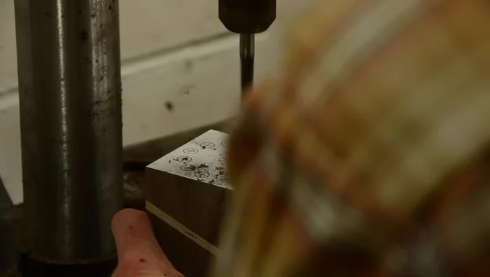 Drill holes according to your pattern (5/16 inch holes for pencils, a 1-inch hole for other items).