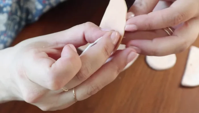 Thread through the back of the clay pieces, leaving the excess thread facing the wall. 