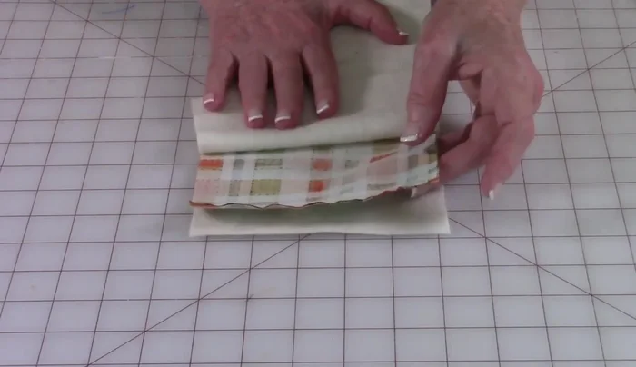 Prepare outer fabric: Layer cotton batting between two outer fabric pieces. Stitch all sides together, leaving a ¼ inch unstitched at the bottom edge.