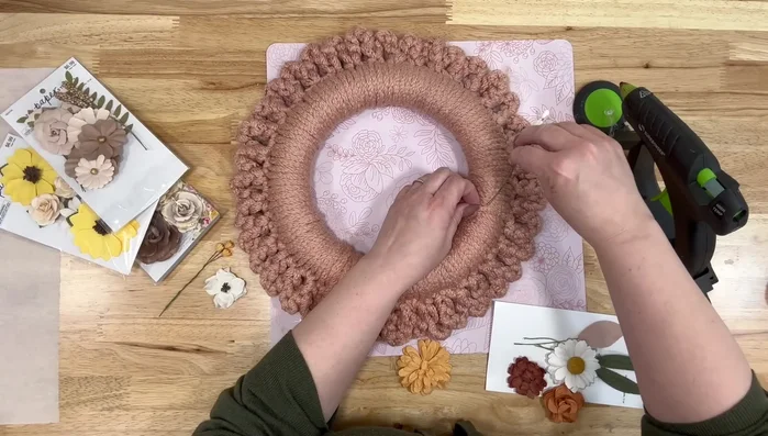 Add embellishments. Use hot glue to attach small flowers or other decorations to the wreath.