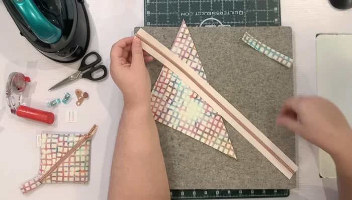 Attach zipper: Place the folded 9in square against one side of the zipper tape, aligning raw edges. Topstitch along the zipper teeth, keeping the fabric butted against the teeth.