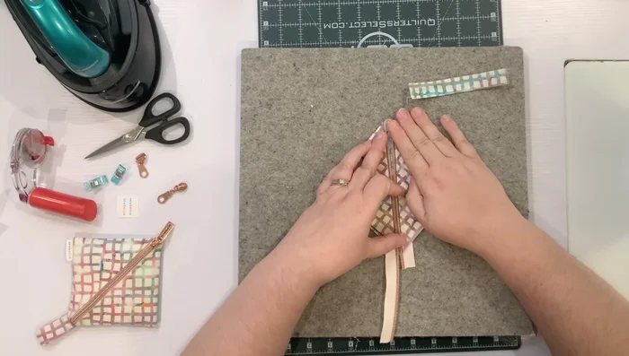 Line up zipper tapes and clip in place. Attach the zipper pull.