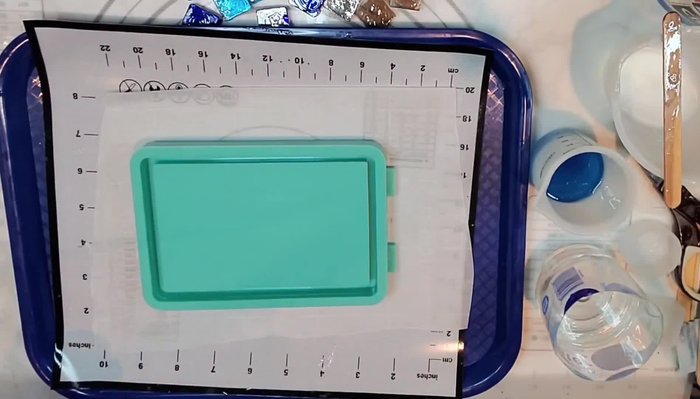 Prepare the tray and resin: Mix resin and add navy translucent ink, addressing any bubbles with a spray and heat gun.