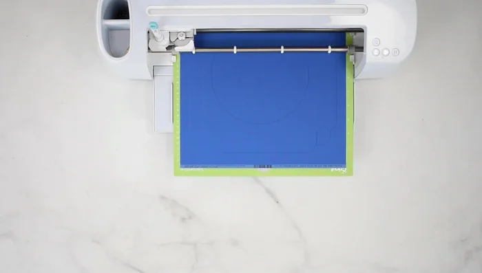 Create a cardstock shadow box frame: Score and cut the cardstock frame pieces using the Cricut. Fold along the scored lines using a bone folder for crisp creases. Apply glue to the tabs and assemble the frame.