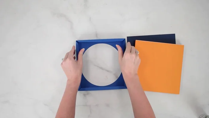 Apply glue to the edges of the cardstock frame's back piece and attach it to complete the shadow box.