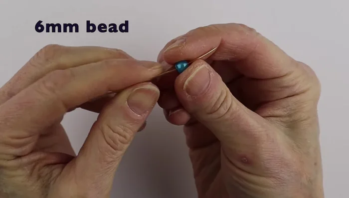 Take your 20 or 22 gauge wire and add your chosen bead in the center. Bend the wire down on both sides to secure the bead.