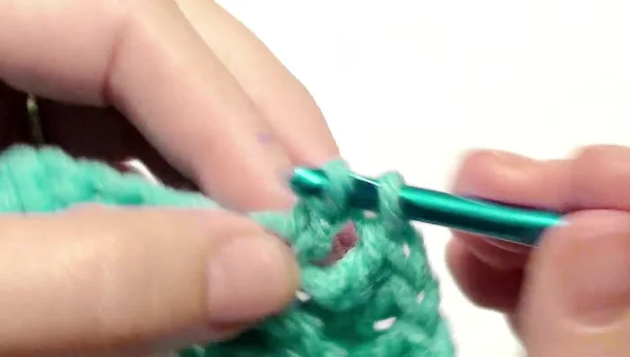 Double crochet in the next nine stitches in the back loop. Alternate between skipping two and the three double crochet after your nine double crochet until you reach the end of the row.