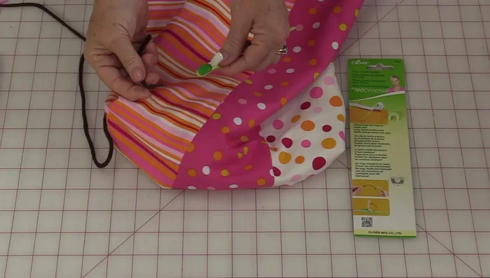 Tie the ends of the drawstrings together on both sides. Tuck the knots to the inside of the bag.