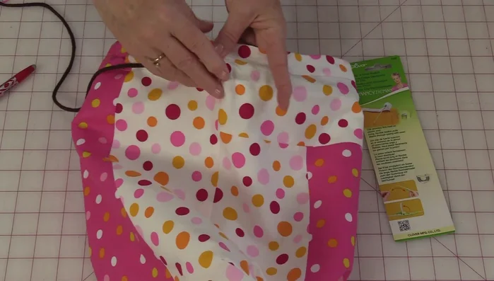 Tie the ends of the drawstrings together on both sides. Tuck the knots to the inside of the bag.