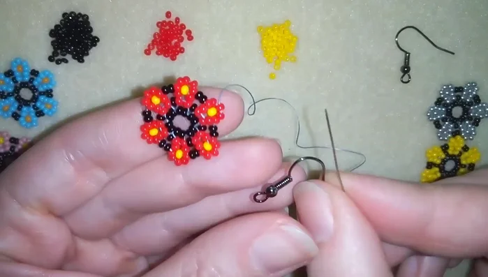 Attach the ear wire by adding one seed bead, the ear wire, and another seed bead. Secure by going back through the beads and making knots at the back.