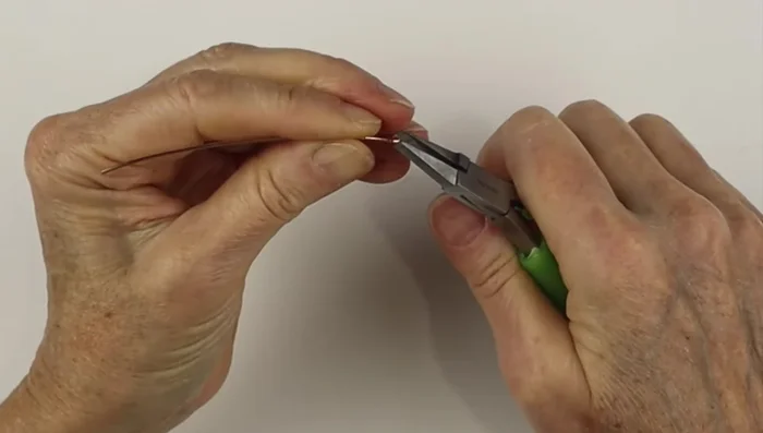 Make a hook clasp using 3 inches of 18 gauge wire. Create a small loop at the end and pinch it closed. Make a hook using bail making pliers. Add a small loop to make it a safety clasp.