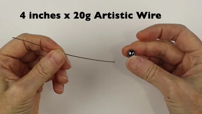 Use bail making pliers to create a loop at one end of the wire, centering it on one side of the bead. Repeat on the other side.
