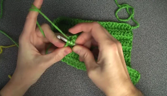 Change to gold yarn. Do not finish the last double crochet of the 14th row, leaving two loops on the hook. Attach the gold yarn and complete the stitch.