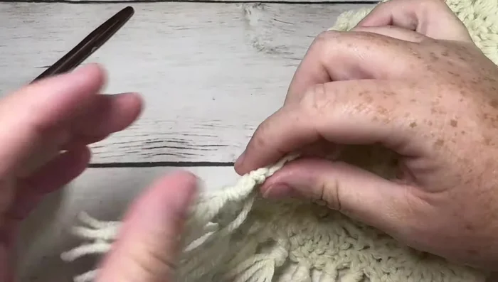 Add fringe (optional): Cut multiple lengths of yarn (approx 7-8 inches), fold in half, pull through every other single crochet stitch, tie a knot. Trim ends to even length.