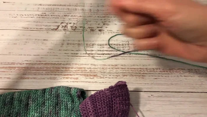 Make a round of decreases (two single crochets together, then two single crochets) to reduce width.
