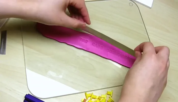 Cut a rectangle around the imprinted message using a long, thin blade. Remove excess clay, smooth the edges, and carefully transfer to a baking surface.