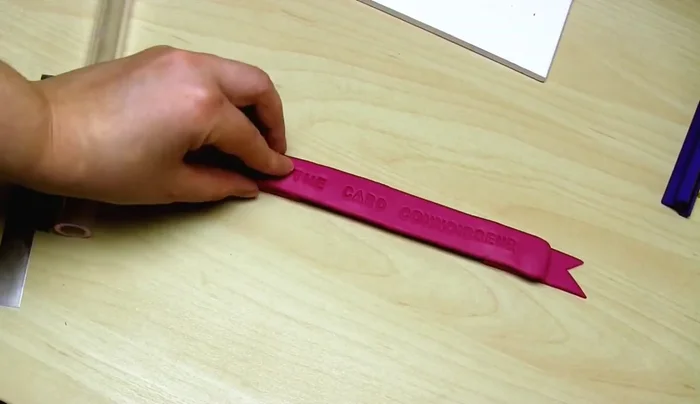 Assemble the banner. Optionally add a clay strut to the back for extra strength. Attach end pieces using clay, fill in gaps, smooth with fingers. Bake.