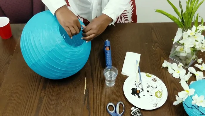 Assemble the paper lantern: Insert the small part of the lantern into the top hole and push it through.