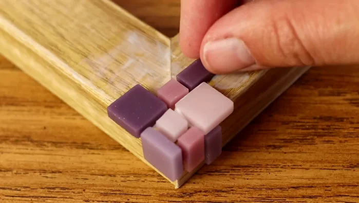 Place tiles randomly but neatly, maintaining even spacing and straight lines. Blend colors seamlessly by adding tiles of the previous color.