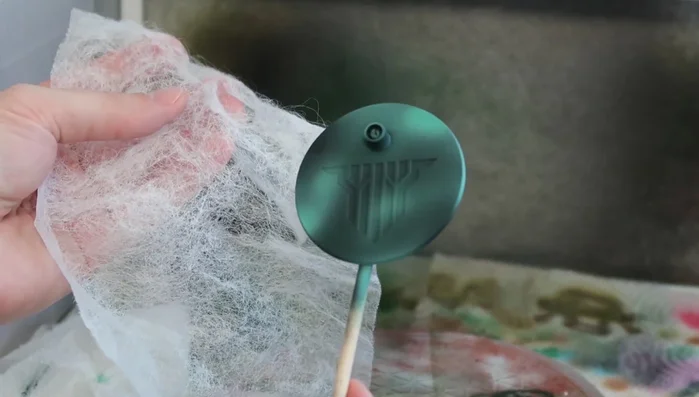 Apply grey and white acrylic paints randomly over the bounce sheet, varying the application.