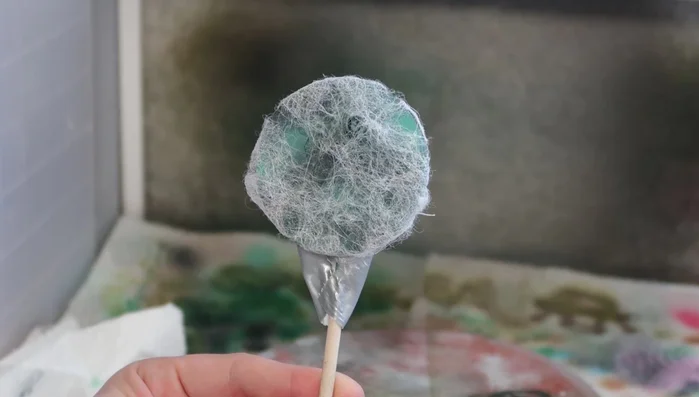 Apply grey and white acrylic paints randomly over the bounce sheet, varying the application.