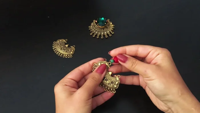 Create the side pendant pieces: Attach one pin with three contrasting beads to each side of the metal piece, using the extreme holes.