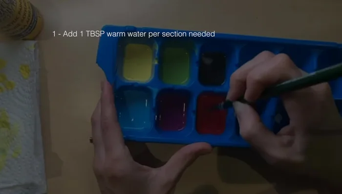 Prepare your paint mixture: In each section of the ice tray, mix 1 tablespoon of warm water, 1 drop of conditioner, and 1 tablespoon of paint. Stir well until all components are dissolved.