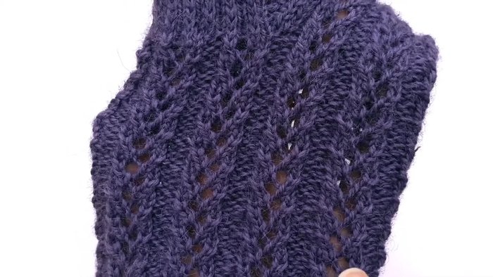 Casting on and beginning the first round: The first stitch is a purl stitch, followed by four lace stitches and one more purl stitch. This pattern is repeated around the sock to create ribbed rows of lace.