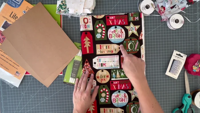 Prepare materials: Gather Christmas fabrics, paper, ribbon, pens, fusible web, hole punch, iron, and sewing machine (optional).
