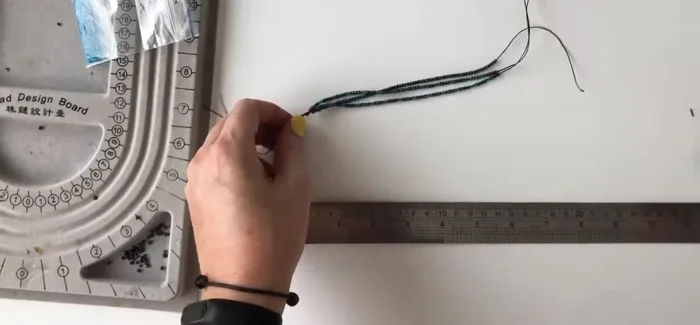 Tie a knot at the loose ends of the threads to create a secure finish.